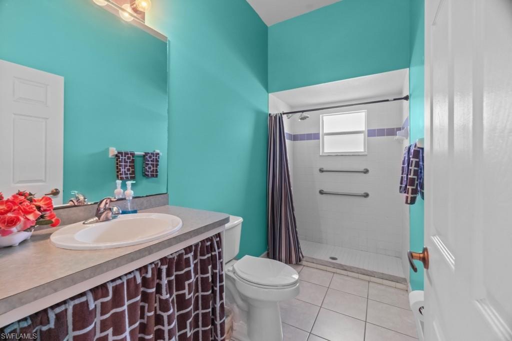 Bathroom featuring a single vanity with an integrated sink, a large wall-mounted mirror, and overhead vanity lighting