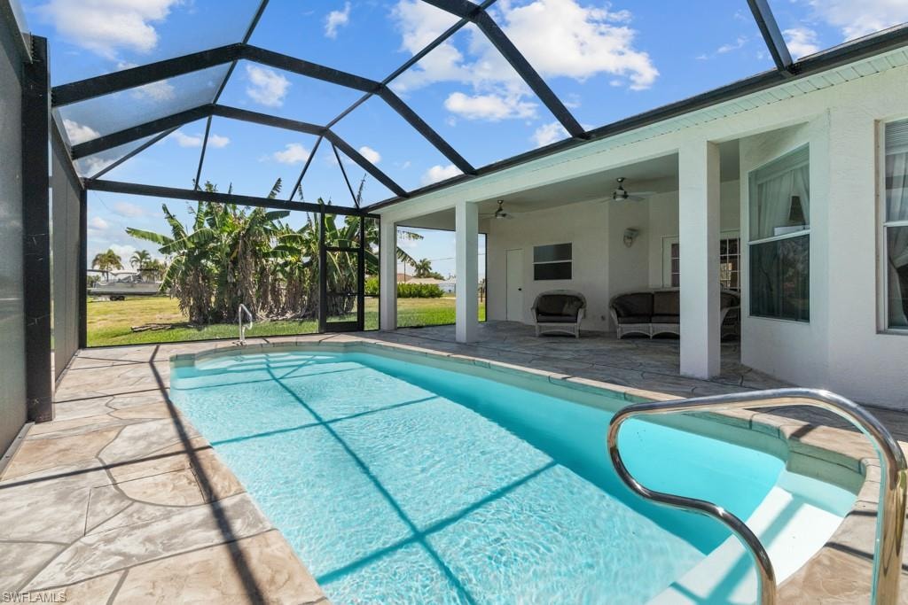 Screen-enclosed swimming pool with stone-finish decking and integrated grab rail