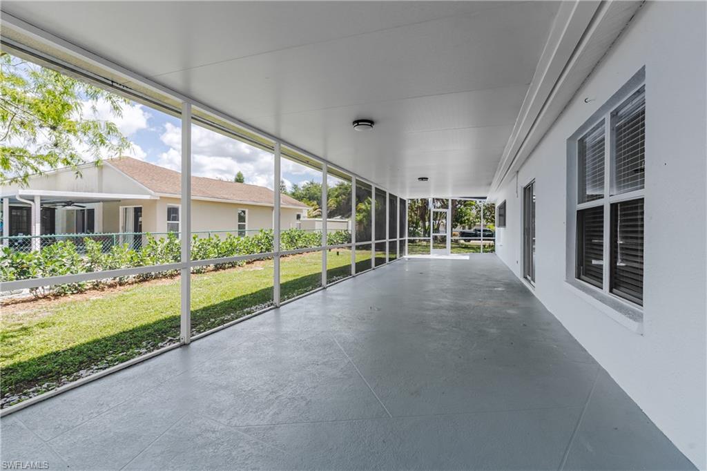 Expansive screened porch featuring a covered ceiling, recessed lighting, concrete flooring, and direct access to the exterior yard space