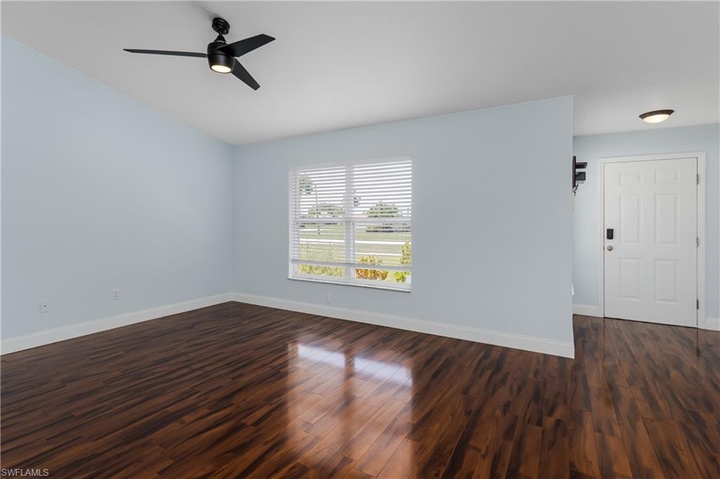 Bright living area featuring wood-finish flooring, light blue walls, and a contemporary ceiling fan with integrated lighting