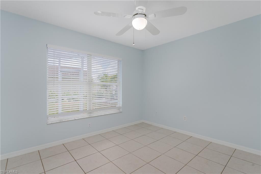 Light blue walls with a window featuring white blinds, complemented by a ceiling fan with integrated lighting