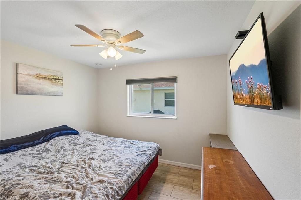 Room featuring a window, light-toned walls, and wood-finish flooring