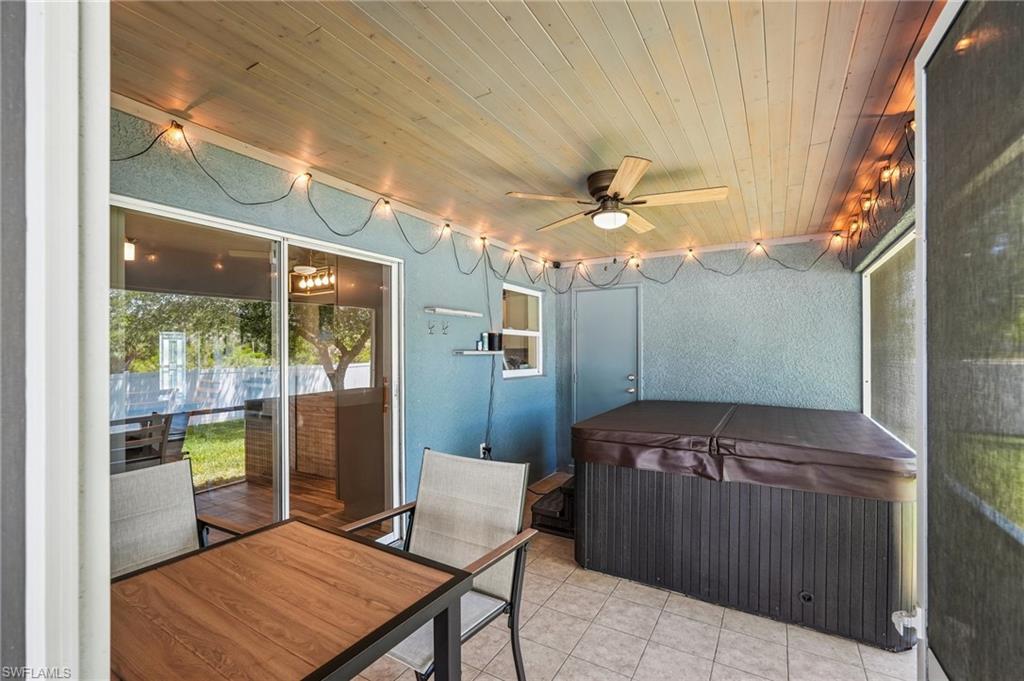Screened patio featuring a wood-finish ceiling, tiled flooring, and a ceiling fan with integrated lighting