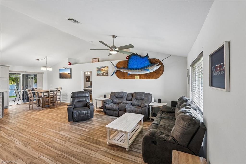 Spacious living area featuring vaulted ceilings and wood-finish flooring