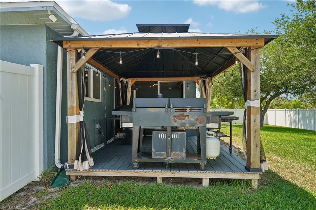 Outdoor gazebo featuring a metal roof, wood-frame construction, string lighting, and decking