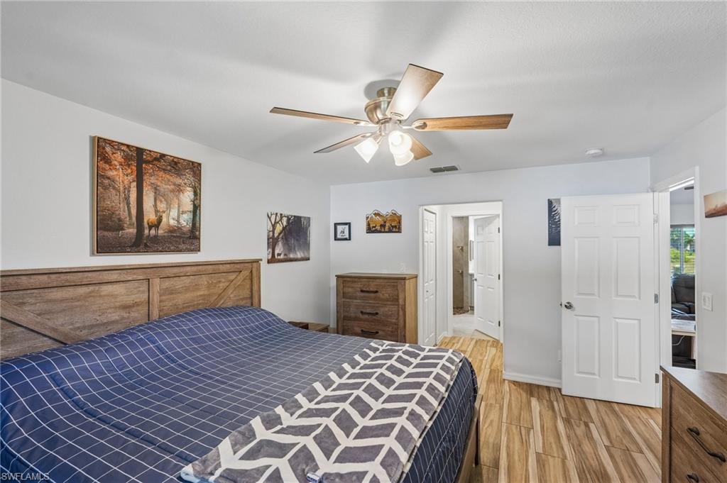 Spacious room featuring wood-finish flooring, a ceiling fan with light fixture, and light-toned walls