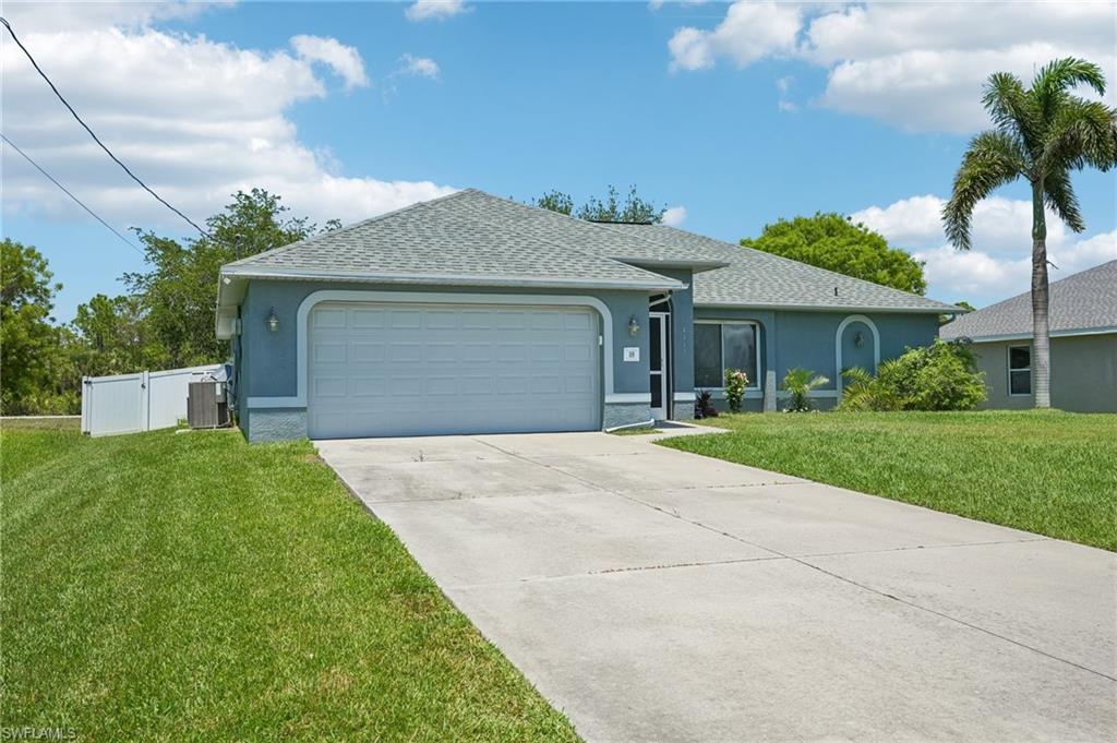 Single-story residence featuring a gray shingle roof, a two-car garage, and a concrete driveway