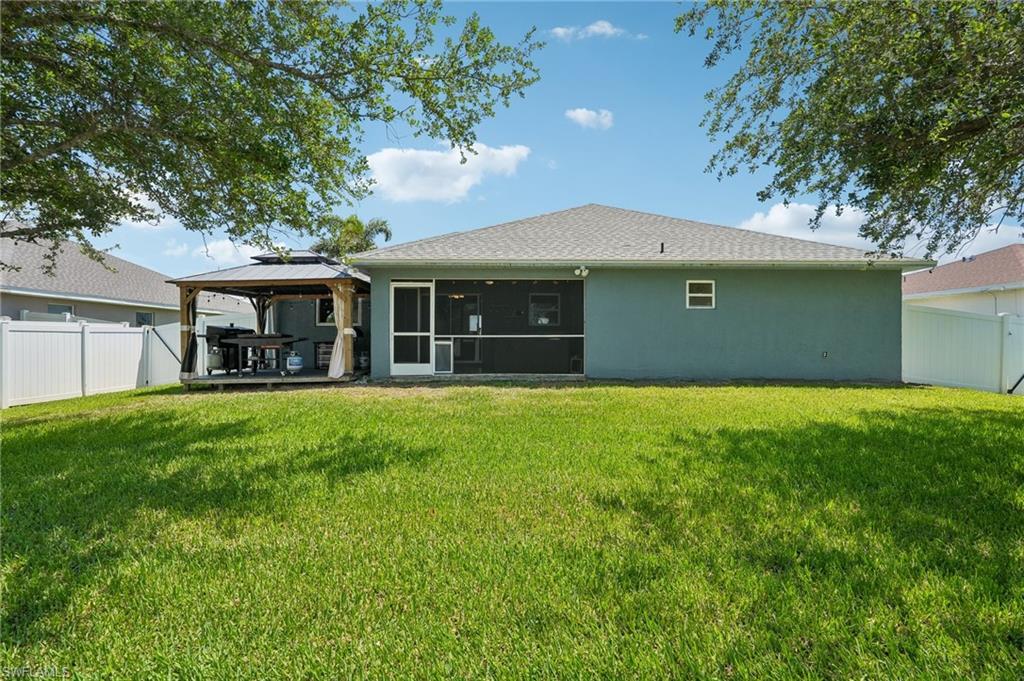 Spacious backyard featuring a covered patio, screened porch, and privacy fencing