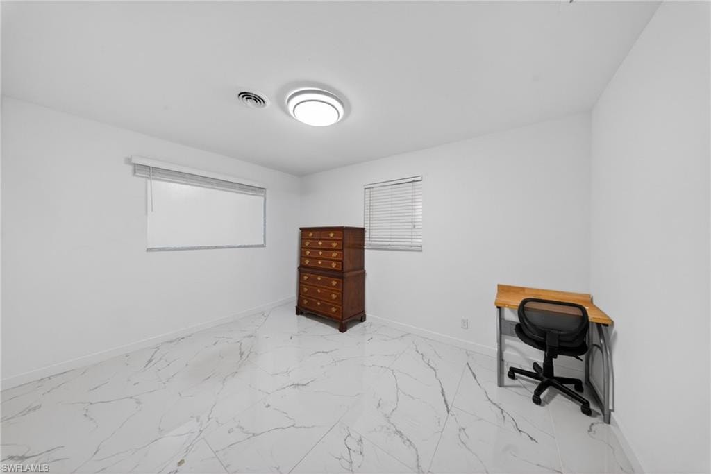 Room featuring white walls, marble-finish tile flooring, a contemporary flush mount ceiling light, and two windows with blinds