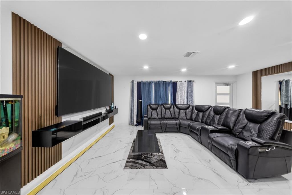 Living area featuring a modern media wall with wood-finish paneling and a floating entertainment console