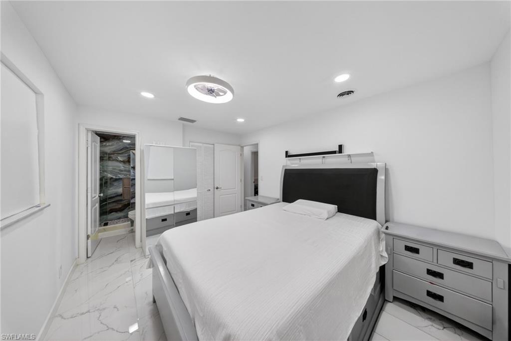 Bedroom featuring white walls and marble-look tile flooring
