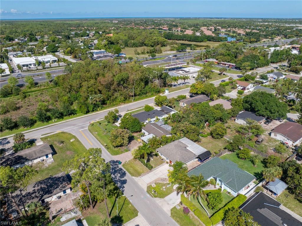 Aerial perspective of a residential area featuring single-family homes with various roof styles and mature landscaping