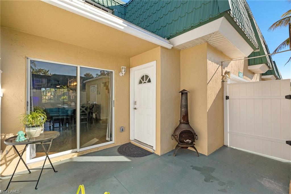 View of exterior entry with stucco siding and a patio area