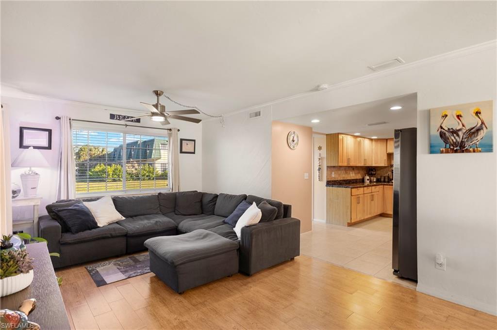 Living area with crown molding, light wood finished floors, ceiling fan, and recessed lighting