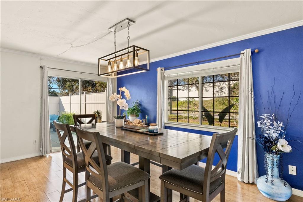 Dining area featuring plenty of natural light, a chandelier, light wood-type flooring, and ornamental molding