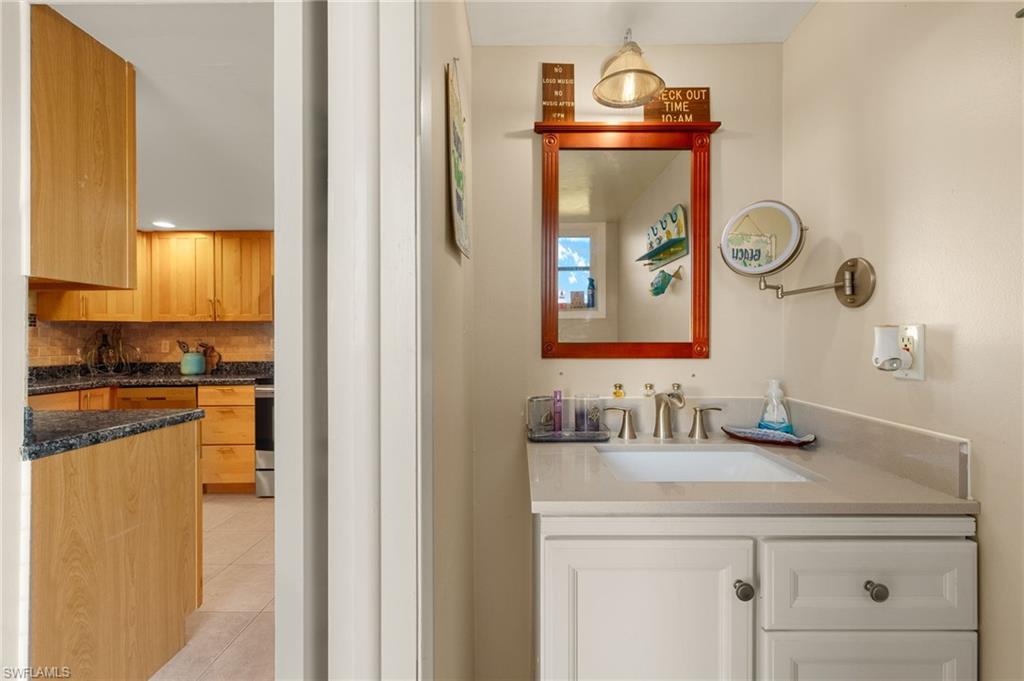 Bathroom with vanity, tile patterned floors, and backsplash
