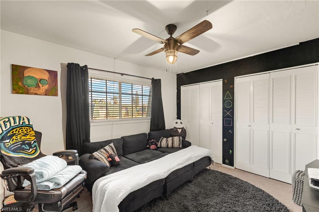 Bedroom featuring two closets, carpet floors, and ceiling fan