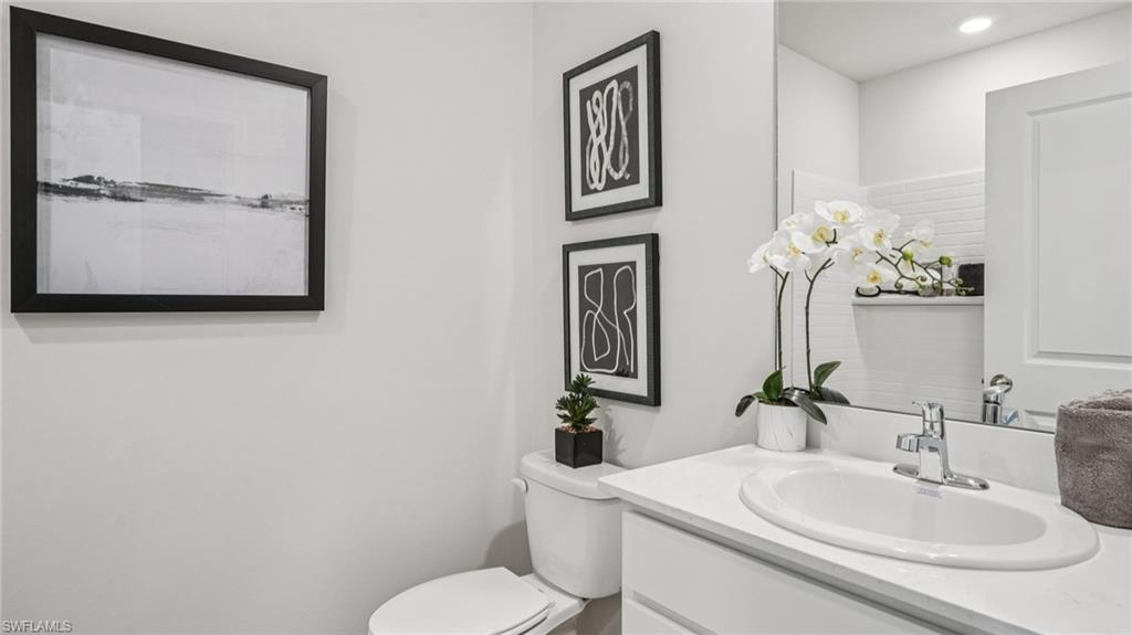Bathroom vanity featuring an integrated sink, polished chrome faucet, and expansive wall-mounted mirror