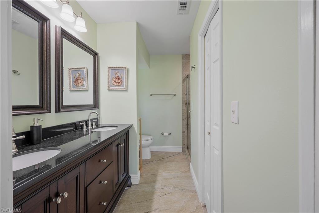 Owner's bath with double sink vanity, walk in closet, and updated shower