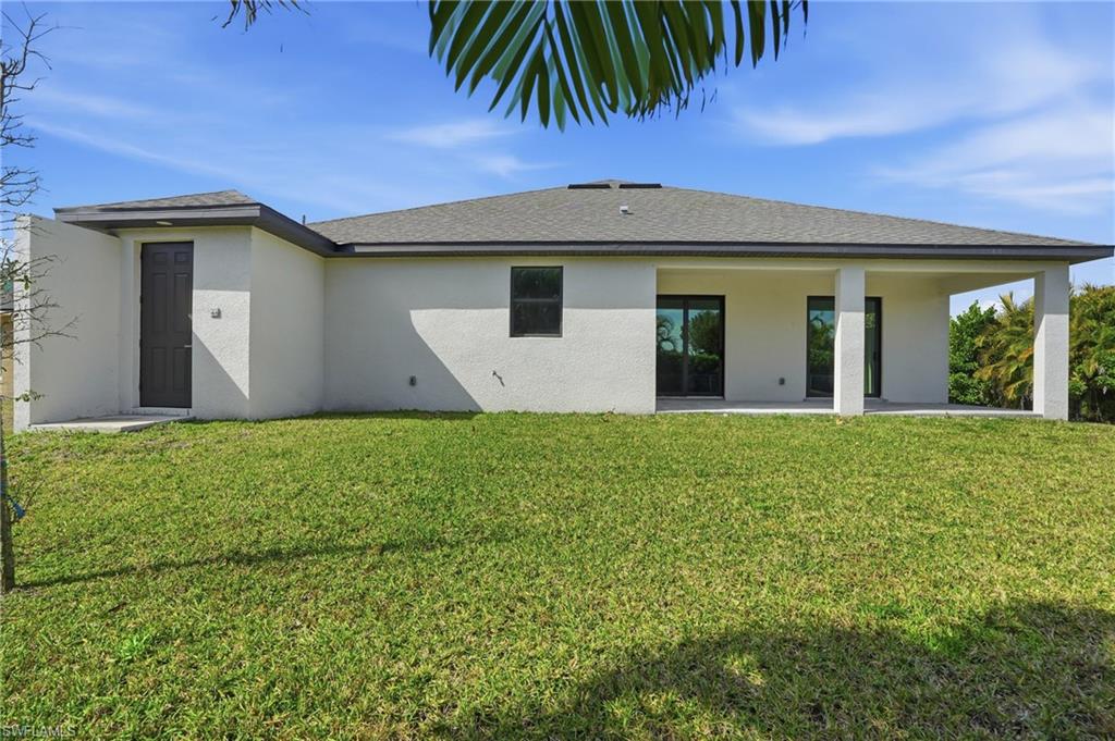 Expansive green lawn bordering the rear exterior of the property
