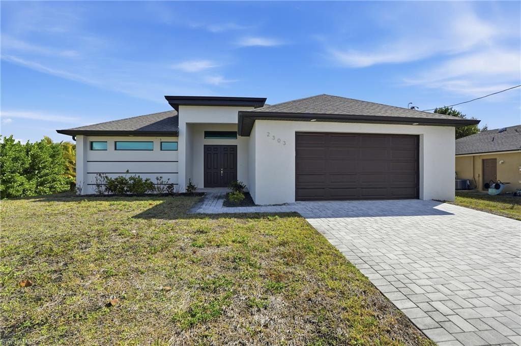 Contemporary stucco exterior with a dark brown garage door, double entry doors, a paver driveway, and horizontal transom windows