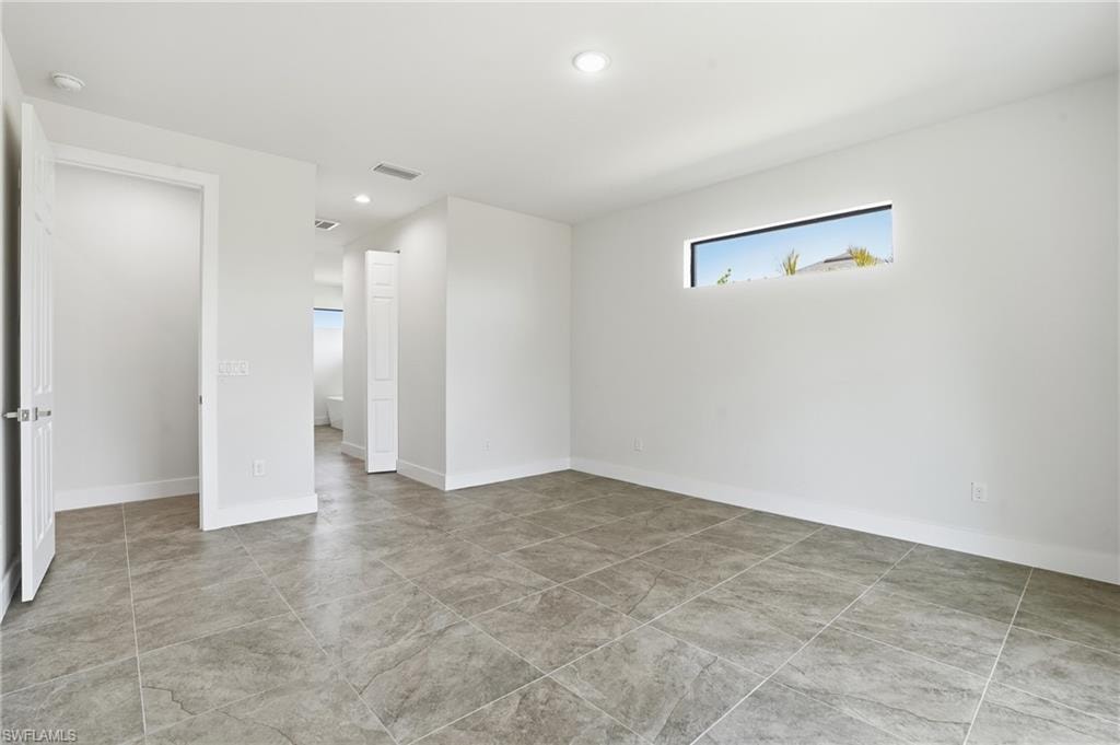 Spacious interior with large format tile flooring and a horizontal window