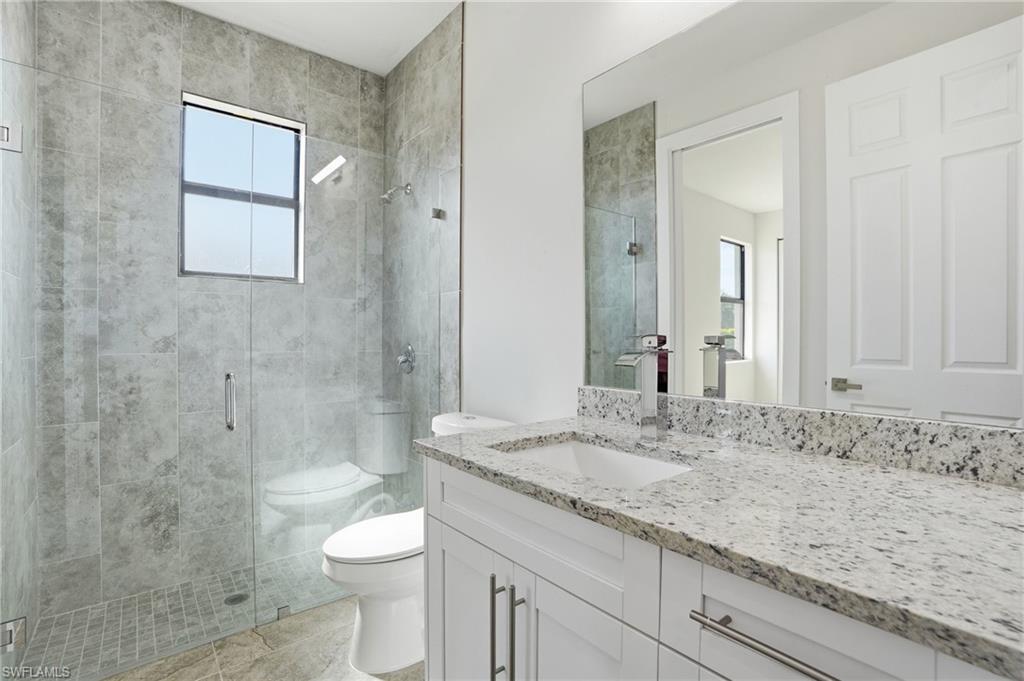Contemporary bathroom featuring a spacious glass-enclosed shower with gray tiled walls and a window