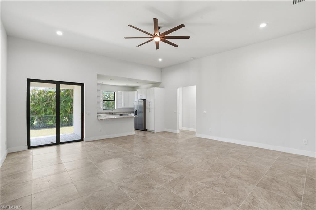 Spacious living area featuring large format tile flooring, recessed lighting, and a contemporary ceiling fan