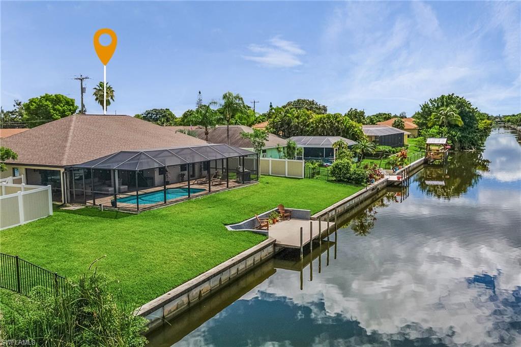View of dock with a fenced in pool, a yard, a water view, glass enclosure, and a fenced backyard