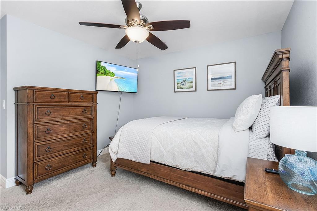 Bedroom with a ceiling fan and light colored carpet
