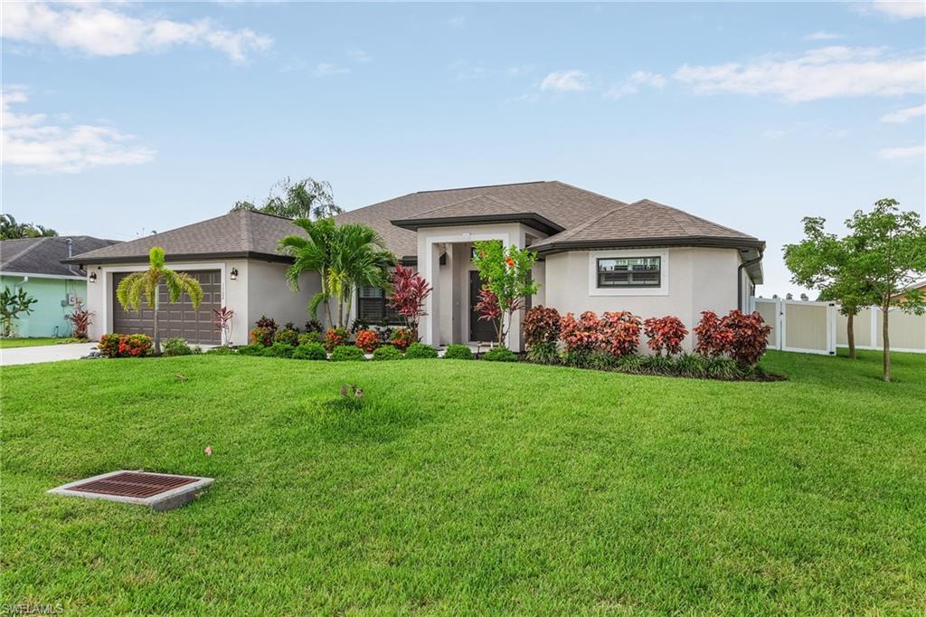 View of front of home featuring concrete driveway, fence, an attached garage, and stucco siding