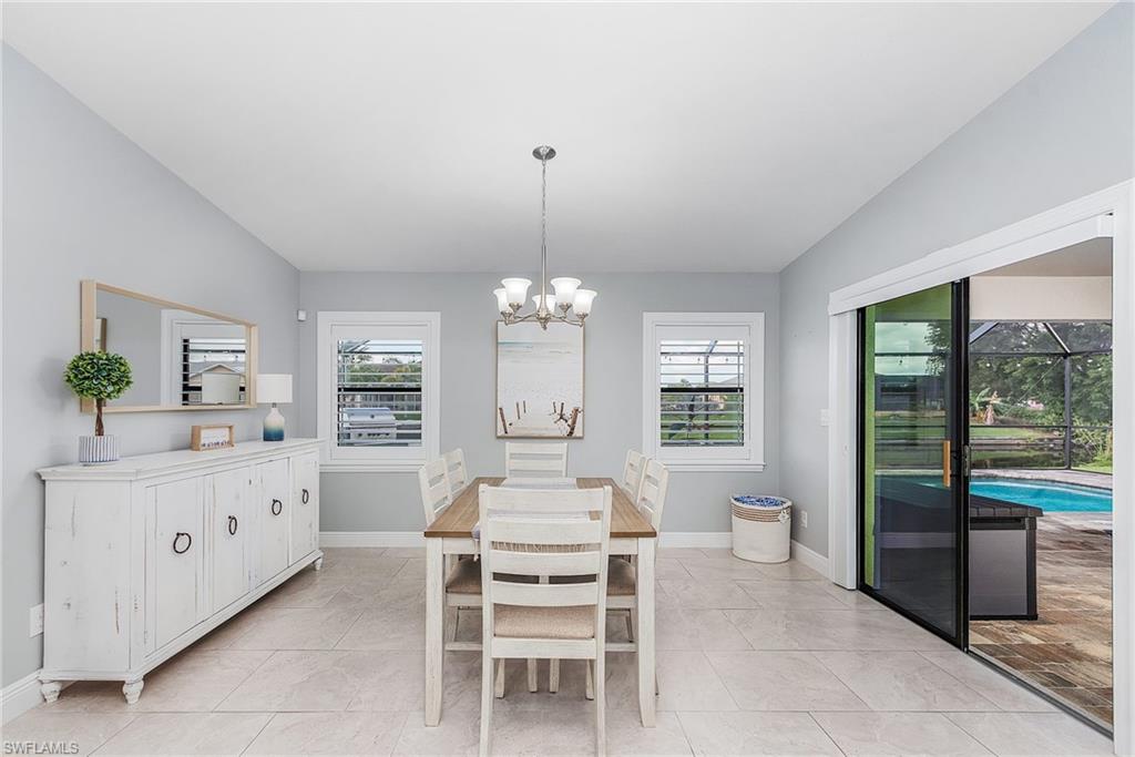 Dining room with a healthy amount of sunlight, a notable chandelier, and baseboards