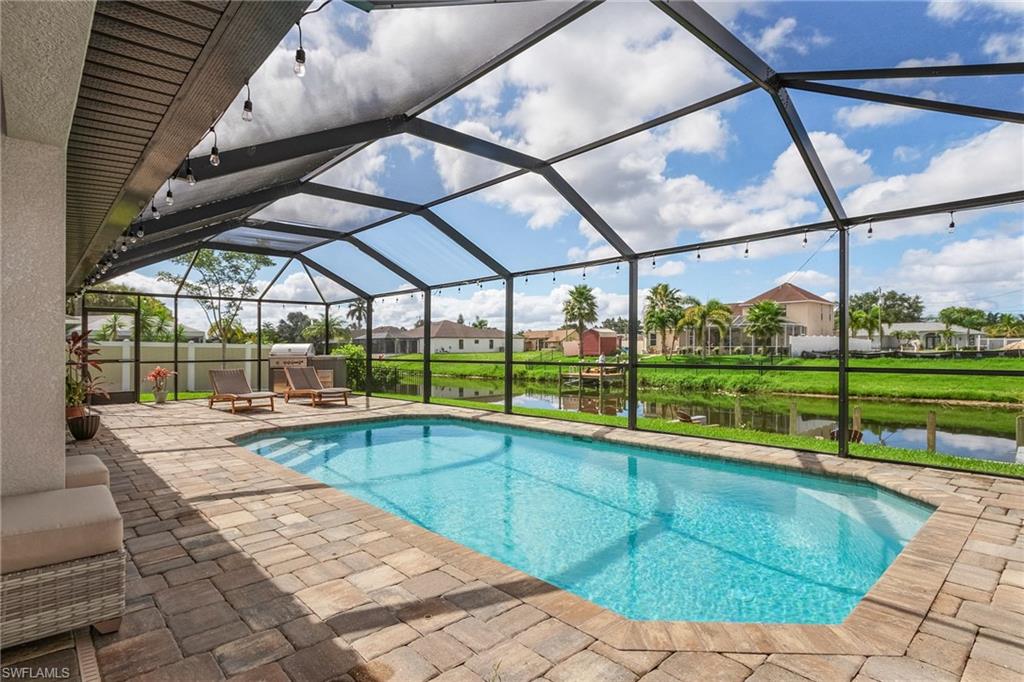 Pool featuring a patio, a water view, and glass enclosure