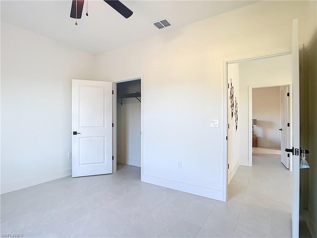 Room featuring light-toned tile flooring, neutral wall tones, and a ceiling fan