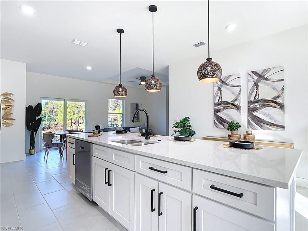 Kitchen island featuring white shaker cabinetry, matte black hardware, and a light-toned countertop