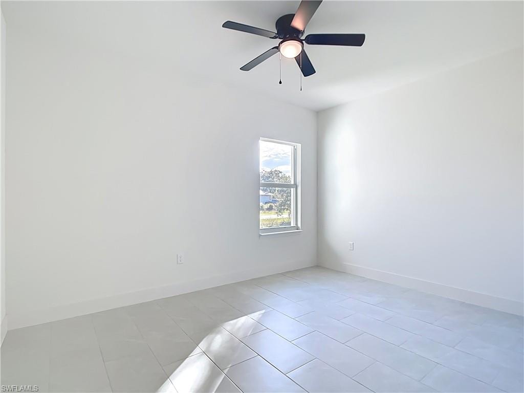 Bright room with white tile flooring and a ceiling fan