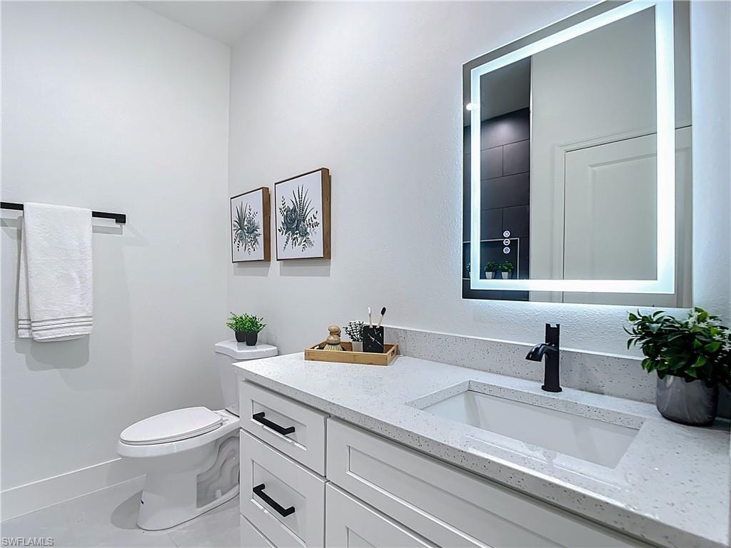 Modern vanity featuring a white quartz-finish countertop with an integrated sink, matte black faucet, and white shaker-style cabinetry with matte black hardware