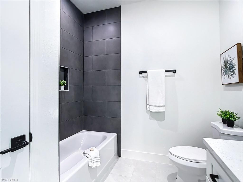 White bathtub with dark gray subway tile surround and integrated shower niche