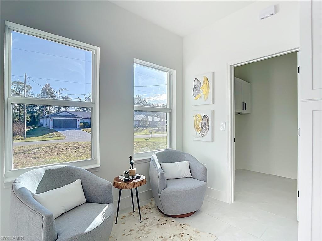 Bright interior space featuring two large windows, light wall paint, and light-colored tile flooring
