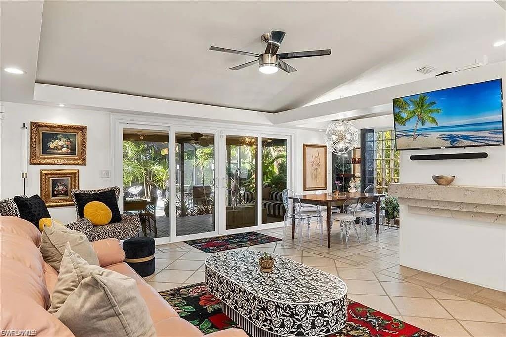Living room featuring ceiling fan, plenty of natural light, lofted ceiling, light tile patterned floors, and recessed lighting