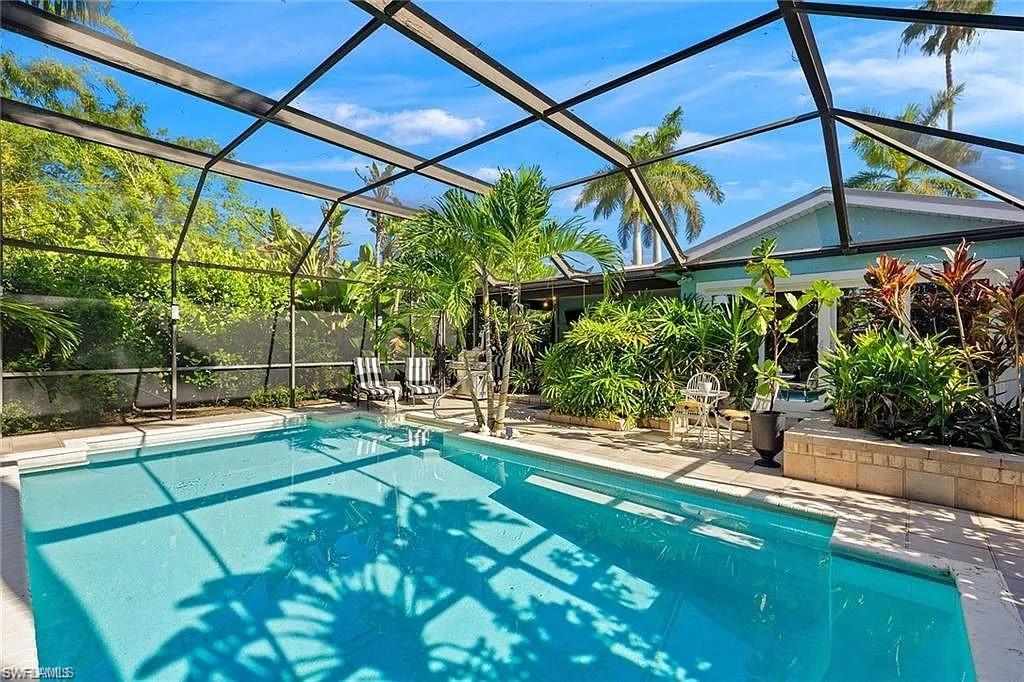 Outdoor pool with a patio and glass enclosure