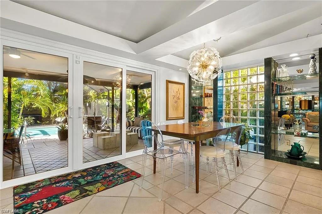 Tiled dining room featuring a chandelier, plenty of natural light, and vaulted ceiling