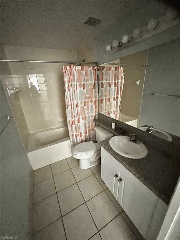 Bathroom featuring a shower-tub combination, ceramic tile flooring, and a vanity with a white basin sink