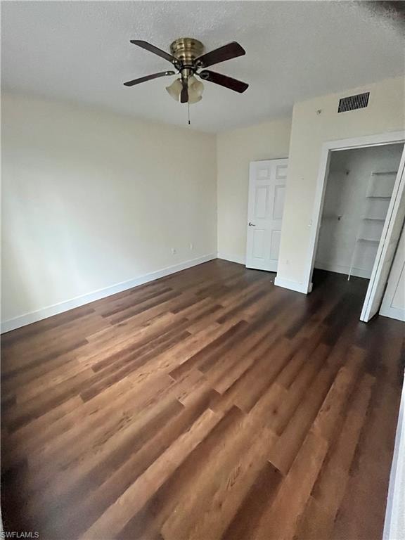 Spacious room featuring wood-finish flooring and a ceiling fan with integrated lighting