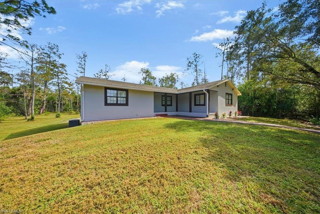 Ranch-style home with a front lawn and stucco siding