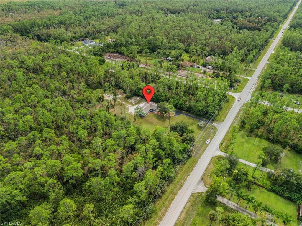 View of property location with a heavily wooded area