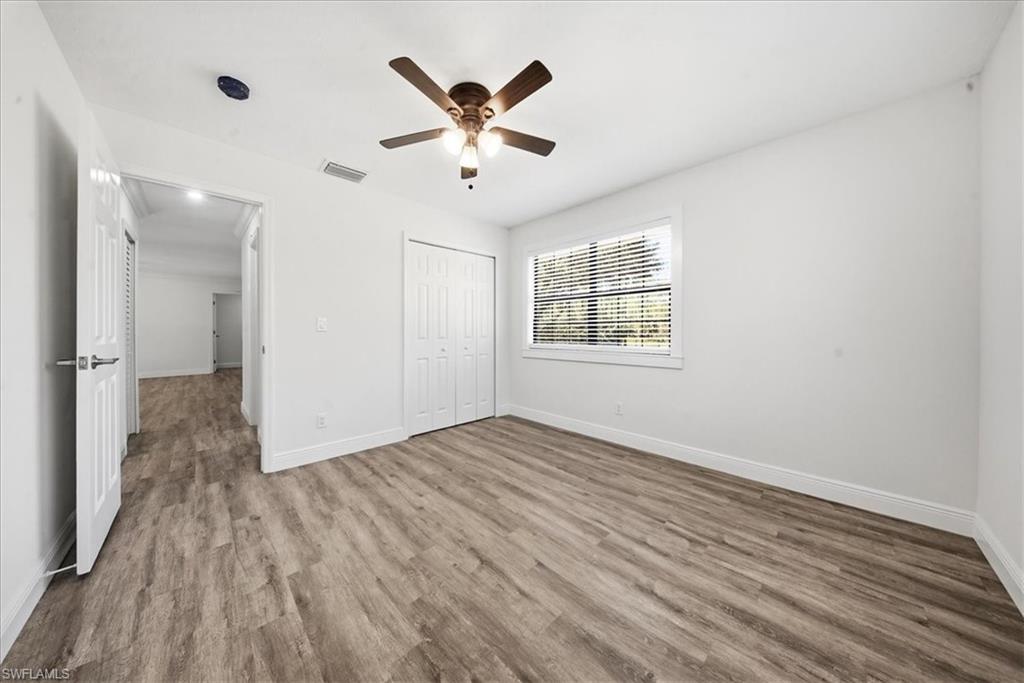 Unfurnished bedroom with wood finished floors, a ceiling fan, and a closet