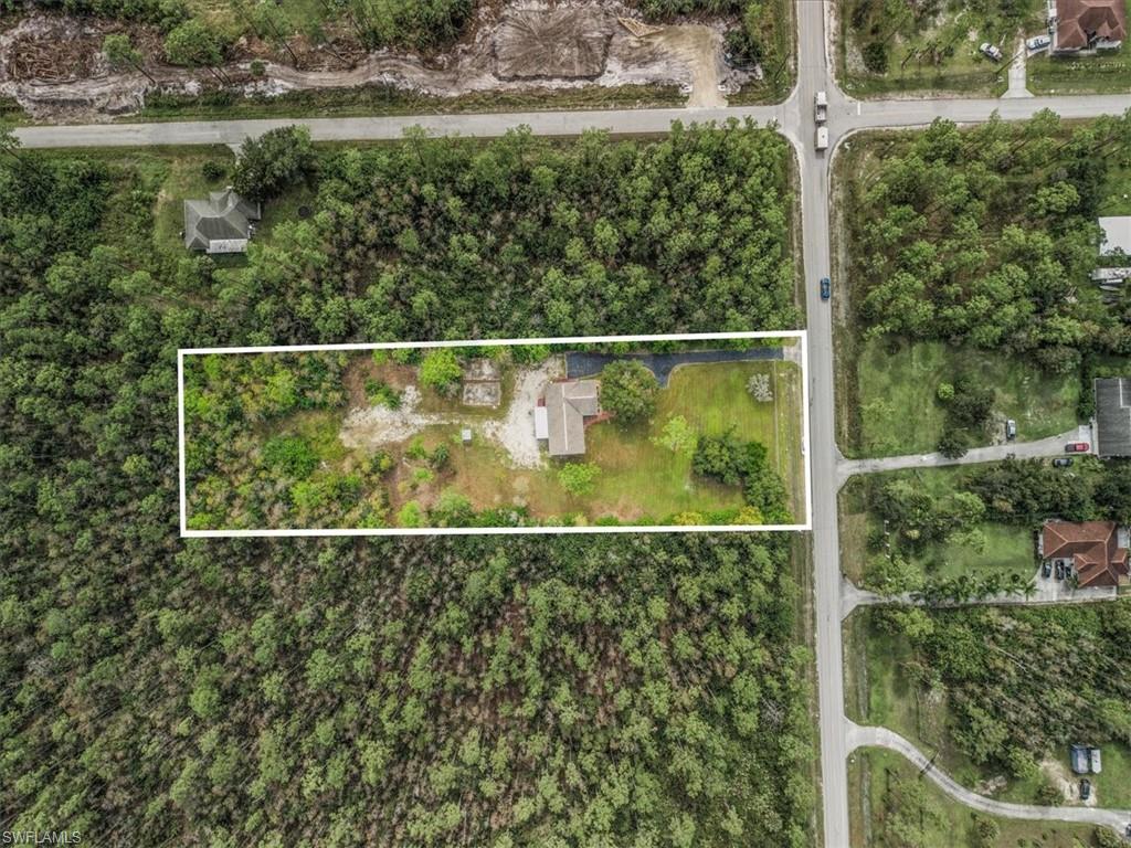 Aerial view of property and surrounding area featuring property parcel outlined