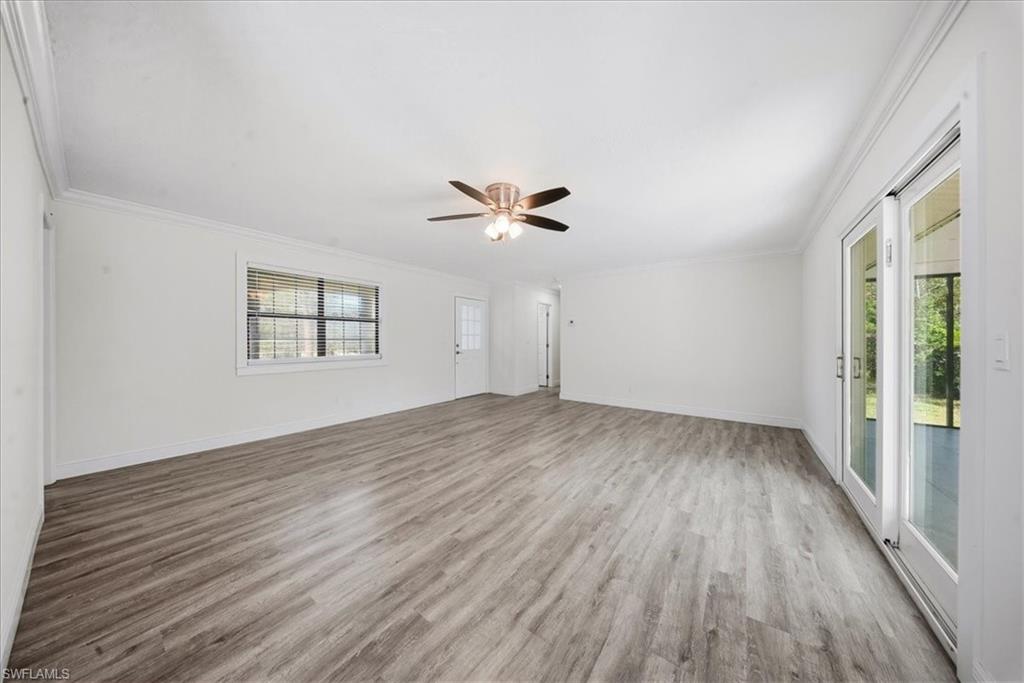 Unfurnished room with crown molding, light wood-type flooring, and ceiling fan