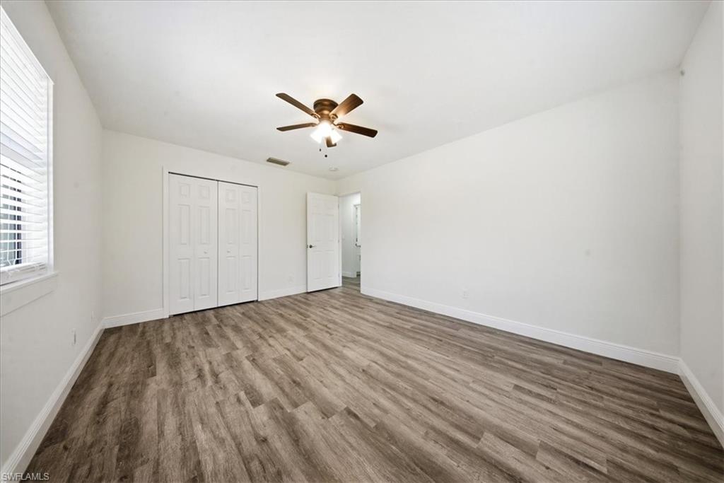 Unfurnished bedroom with a ceiling fan, wood finished floors, and a closet